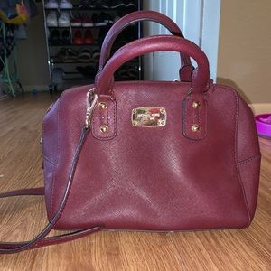 Burgundy Michael Kors purse with cross body strap